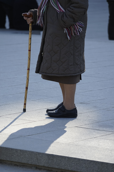 Sony 24-240 mm f/3,5-6,3, posición tele, señora con bastón rústico