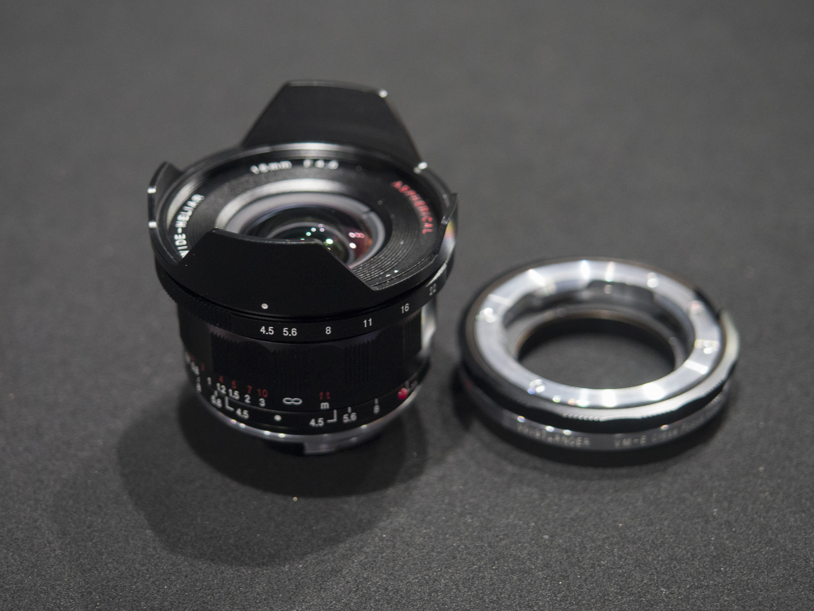Objetivo Voigtländer VM Super Wide Heliar 15 mm f/4,5 Asph III, junto a un adaptador