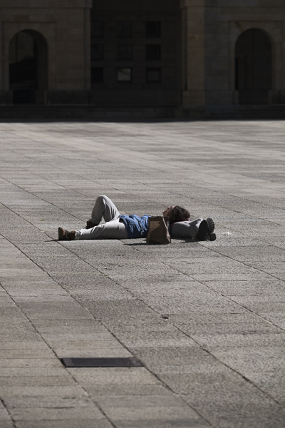 Laboral Ciudad de la Cultura, una persona toma el sol tumbada en el patio