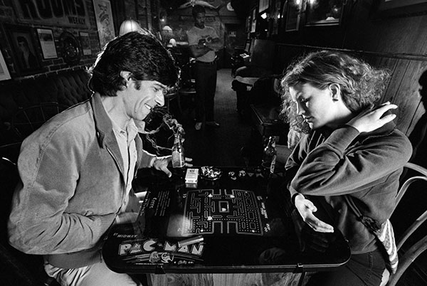 Una pareja jugando a una máquina recreativa